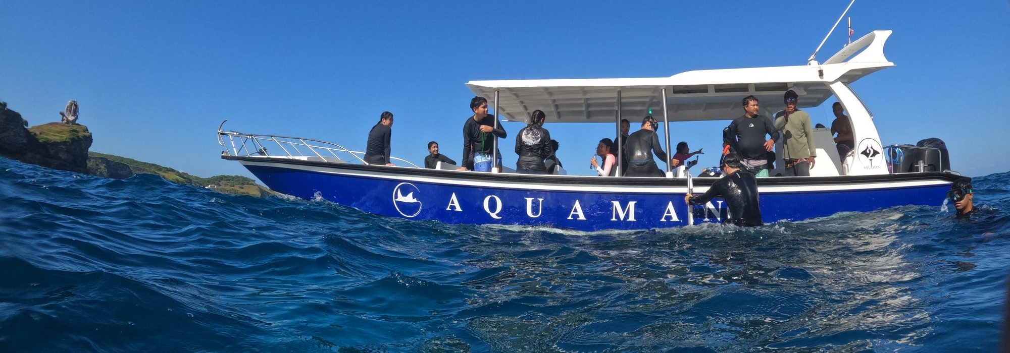 Snorkelers in the water beside a dive boat