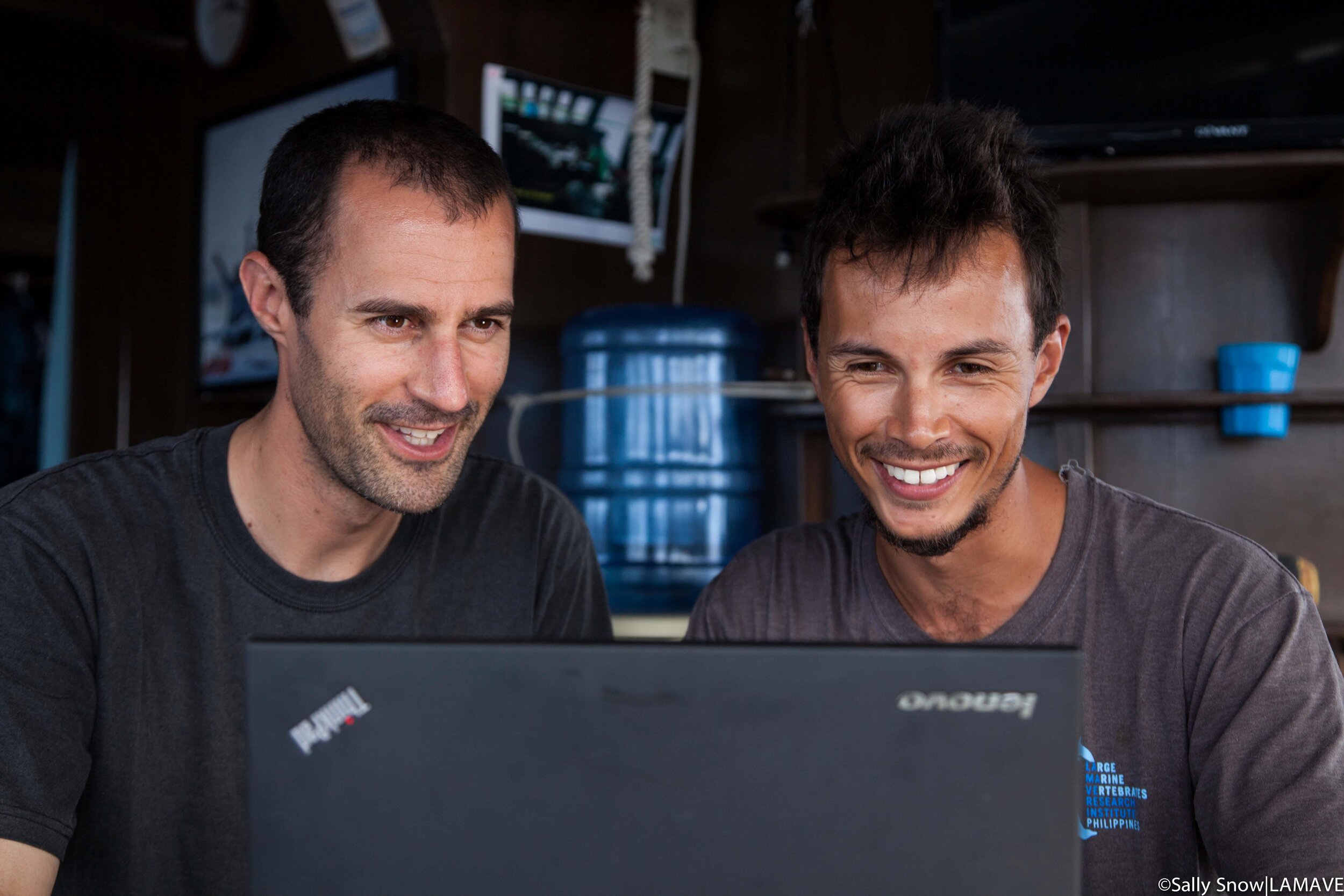 Dr. Chris Rohner and Joshua Rambahiniarison look at data on a laptop