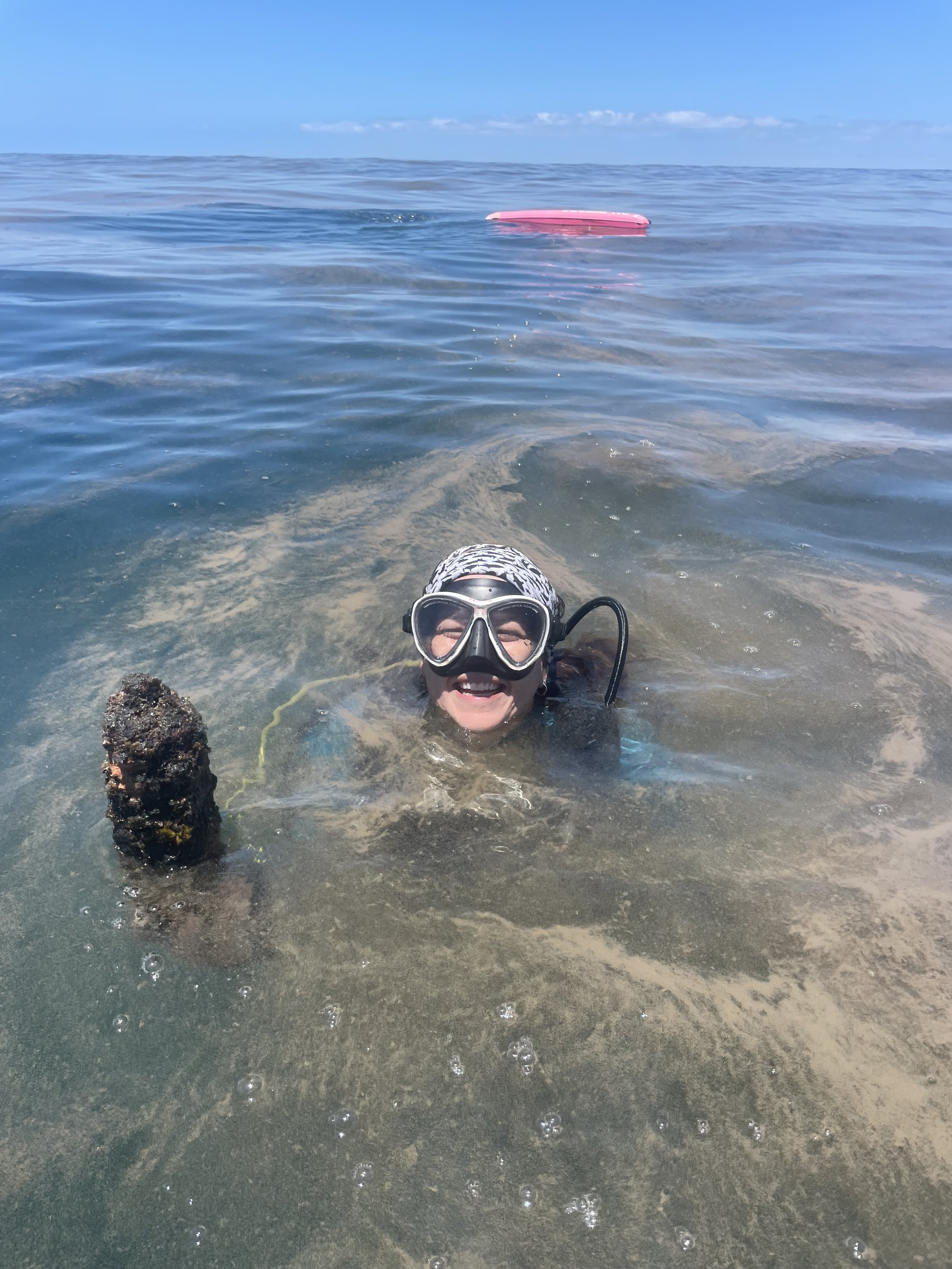 Dr. Nakia Cullain surfaces beside an acoustic receiver recovered from a reef in the Bazaruto Archipelago
