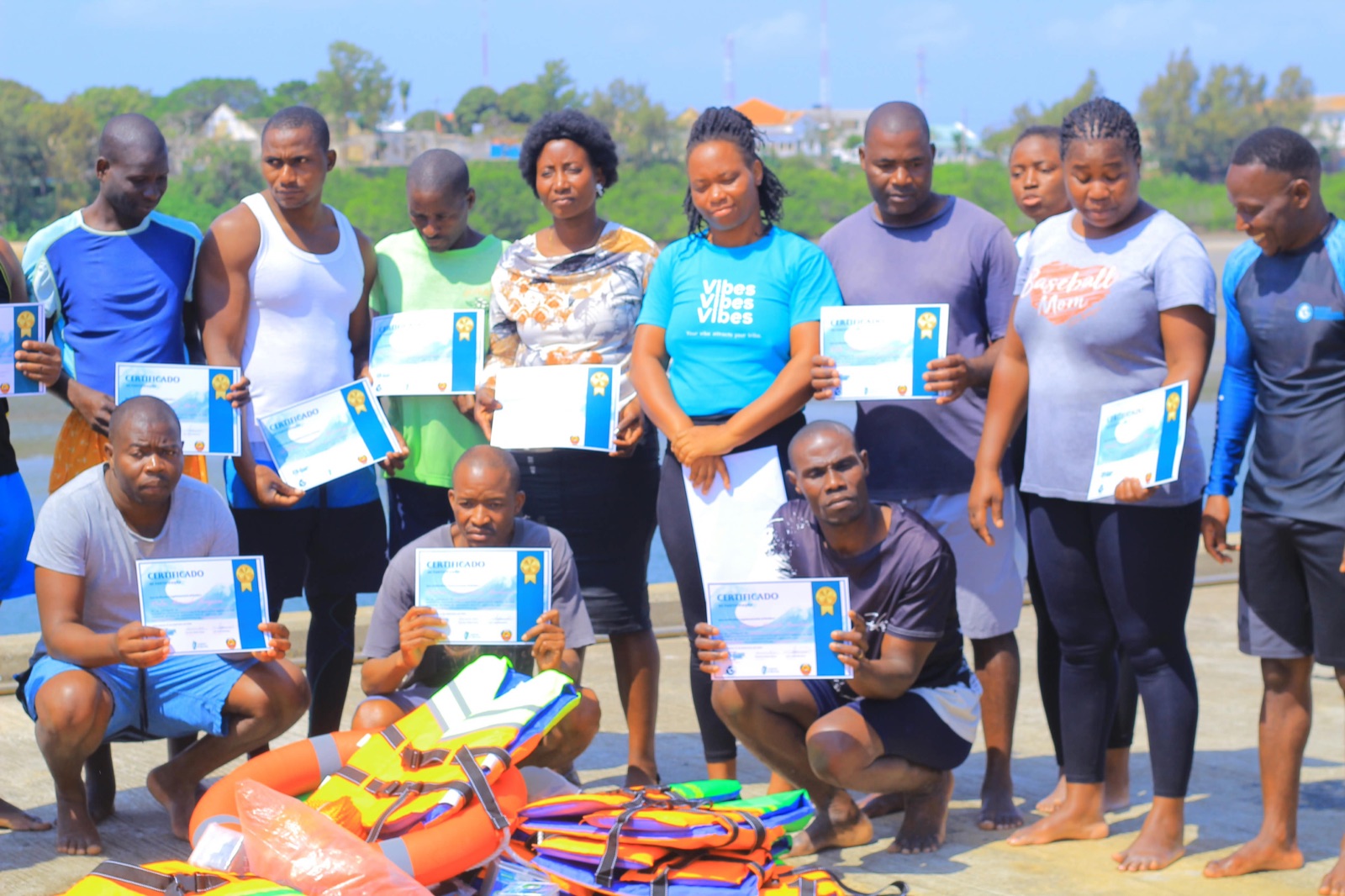Course participants pose with their certificates, with life jackets and a life ring in front of them